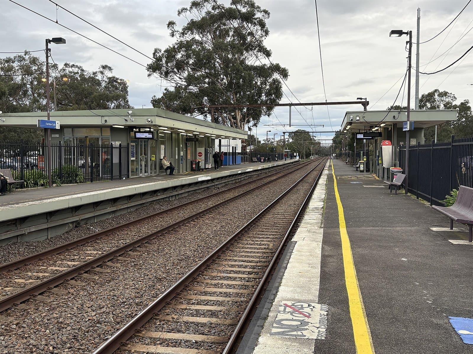 The platforms and tracks of Ferntree Gully railway station under gum trees
